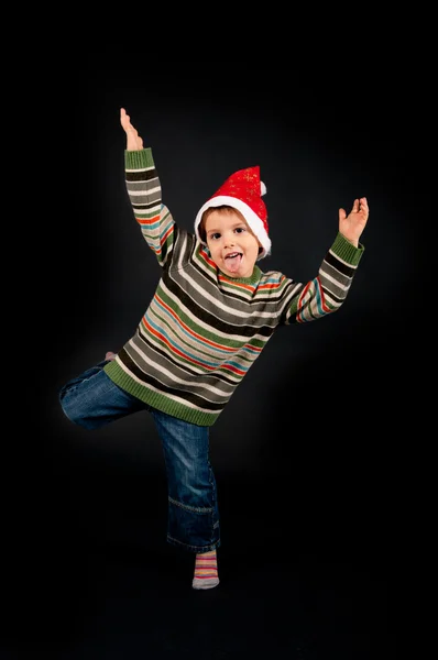 Lustiges Kinderporträt mit Weihnachtsmütze auf schwarzem Hintergrund — Stockfoto