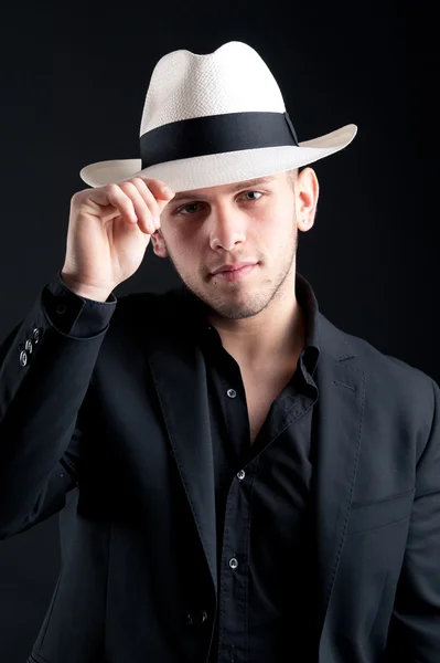 Jeune homme portrait avec chapeau blanc sur fond noir — Photo