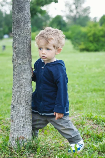 Jeden rok chlapec hraje v parku portrét — Stock fotografie