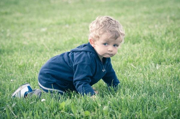 Ettårig pojke spelar i park porträtt — Stockfoto