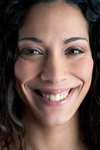 Hermosa chica morena rizada sonriendo sobre fondo oscuro — Foto de Stock