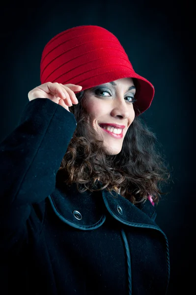 Vacker kvinna i röd hatt mot svart bakgrund. retro porträtt — Stockfoto
