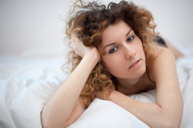 yatakta yatarken, şehvetli genç bir kadın portresi. sığ derinlik-in tarla