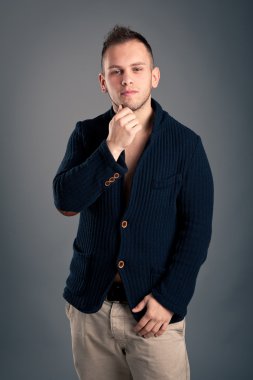 Kendine güvenen casual adam gri arka plan üzerinde düşünme