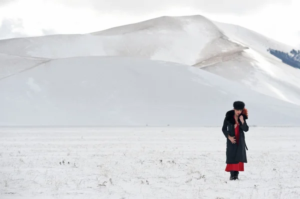 Portret van mooie vrouw met sneeuw in de winterlandschap — Stockfoto