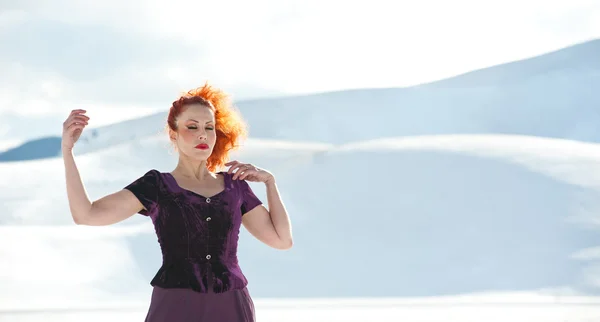 Porträt einer schönen roten Frau, die im Winter im Schnee tanzt — Stockfoto