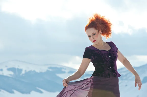 Portrait of beautiful red woman dancing in the snow in a winter — Stock Photo, Image