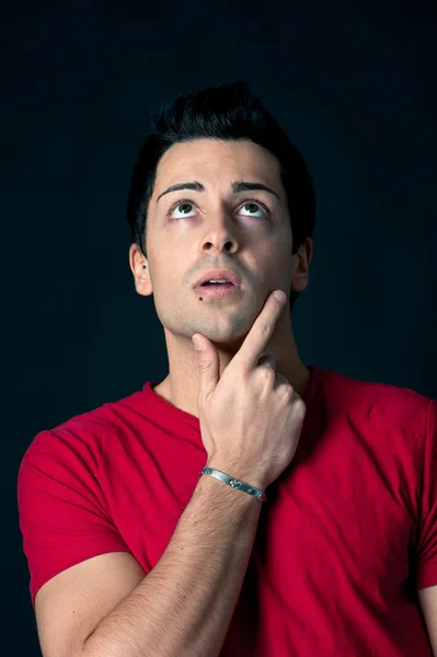 Retrato de hombre dudoso sobre fondo oscuro —  Fotos de Stock