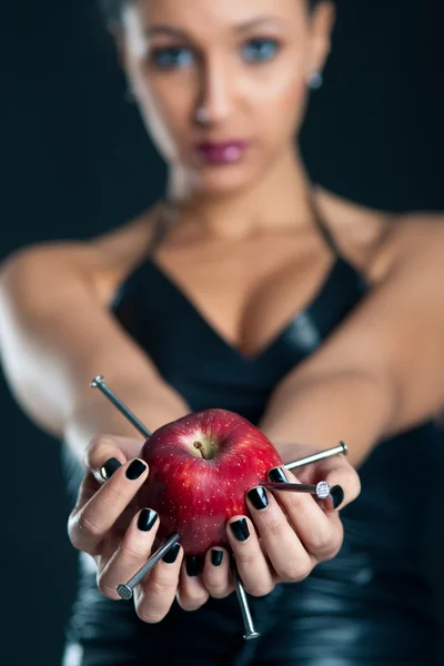 Conceptuele afbeelding van mooi meisje met nagels gedreven apple. ondiepe scherptediepte — Stockfoto