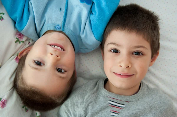 Dois irmãos retrato deitado na cama — Fotografia de Stock