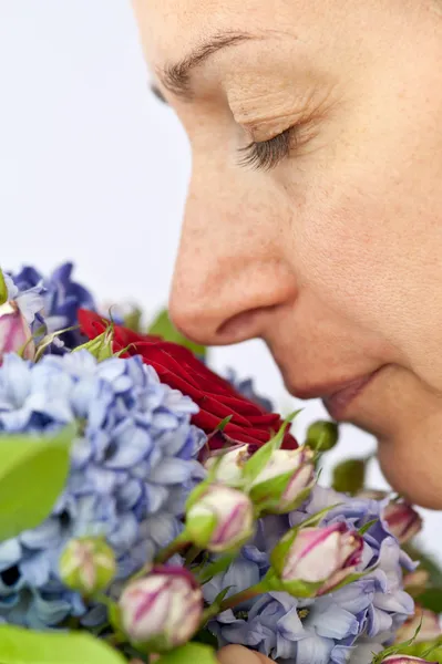 Portret van mooie vrouw een boeket bloemen ruiken — Stockfoto