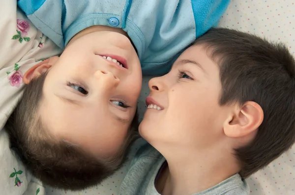 Retrato de dos hermanos acostados en la cama —  Fotos de Stock