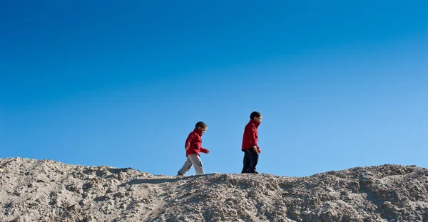 Due fratelli che camminano su una collina di sabbia — Foto Stock