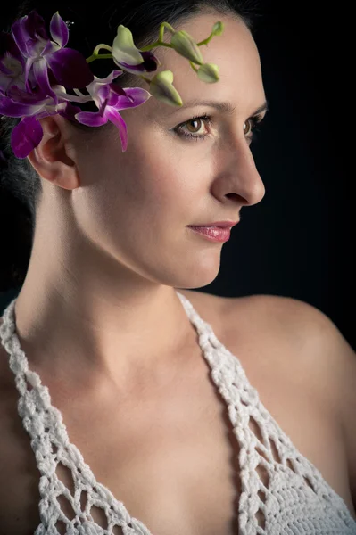 Portret van mooi meisje met roze orchideebloem close-up — Stockfoto