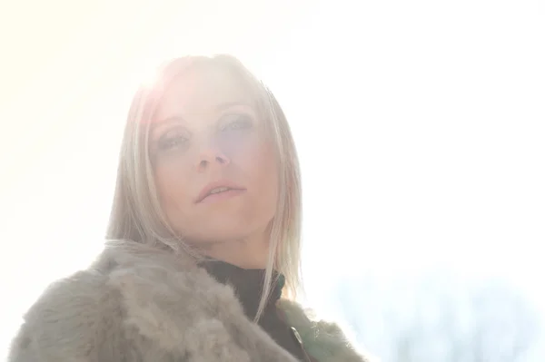 Portrait of young attractive woman with fur, backlight — Stock Photo, Image