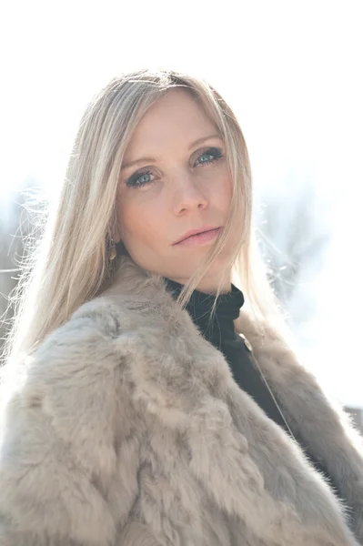 Portrait of young attractive woman with fur, backlight. — Stock Photo, Image