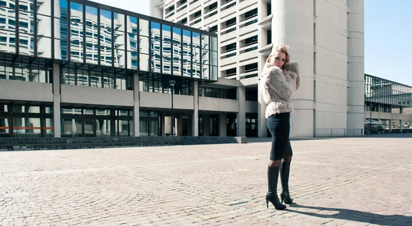 Jovem mulher de negócios atraente com pele na frente do edifício de negócios moderno — Fotografia de Stock