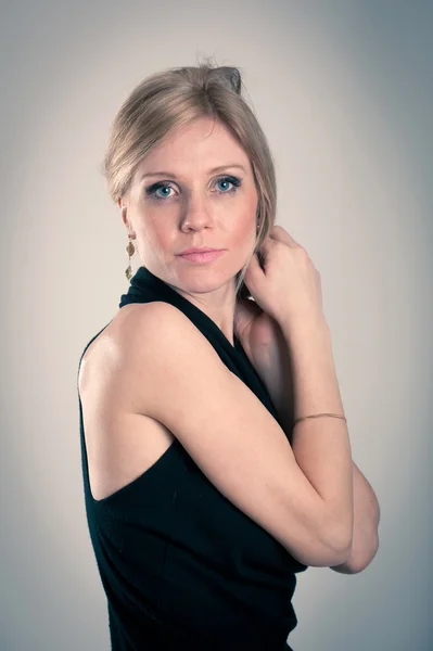 Beautiful blonde caucasian woman with elegant black dress — Stock Photo, Image