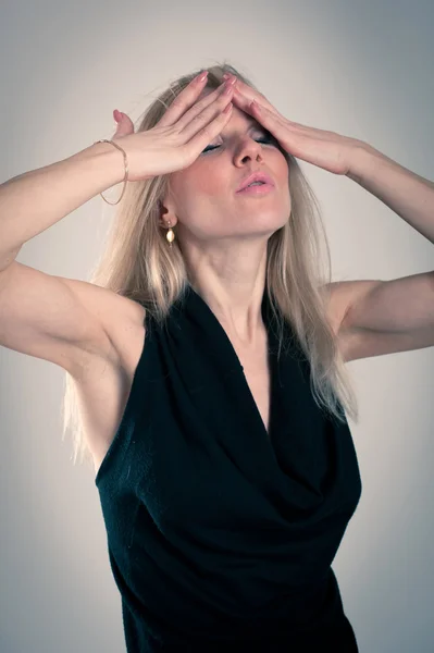 Desperate blonde caucasian woman with elegant black dress — Stock Photo, Image