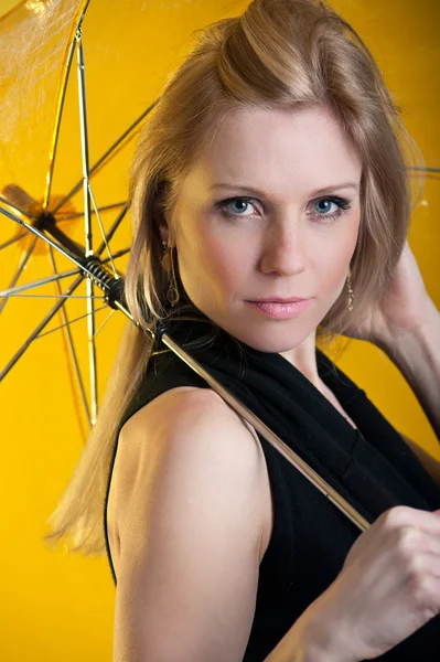 Attractive caucasian blond woman with yellow umbrella — Stock Photo, Image