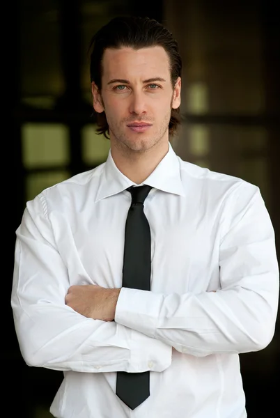 Confident young businessman looking at camera with arms crossed — Stock Photo, Image