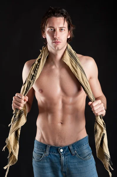 Portrait of confident young man shirtless against black background — Stock Photo, Image