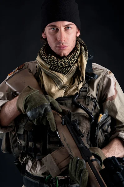 Soldier with rifle against black background — Stock Photo, Image