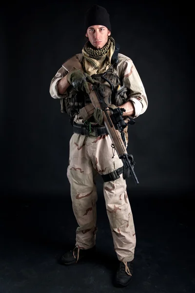 Soldier with rifle against black background — Stock Photo, Image