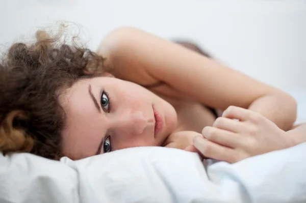 躺在床上一个性感的年轻女子的画像。景深浅 — 图库照片