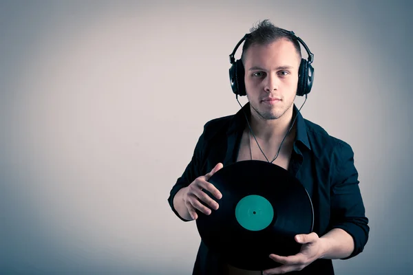 Young man working as dj with ear-phones and disc — Stock Photo, Image