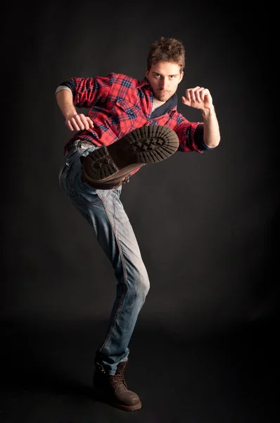 Jonge man schoppen tegen zwarte achtergrond — Stockfoto