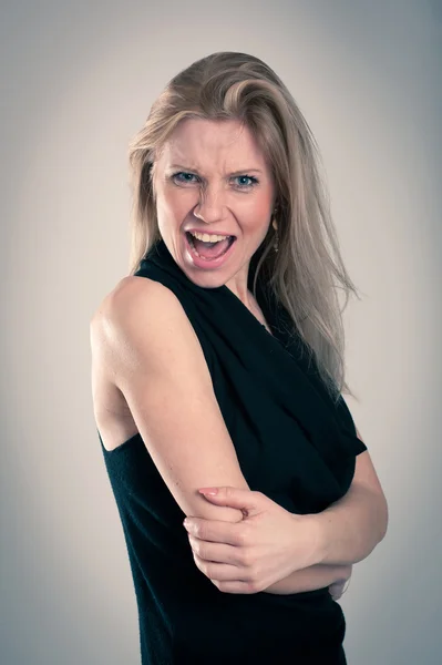 Angry blonde caucasian woman with elegant black dress Royalty Free Stock Photos