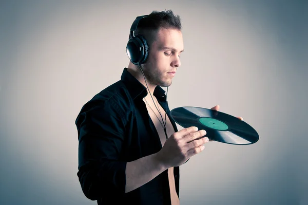 Young man working as dj with ear-phones and disc Royalty Free Stock Photos