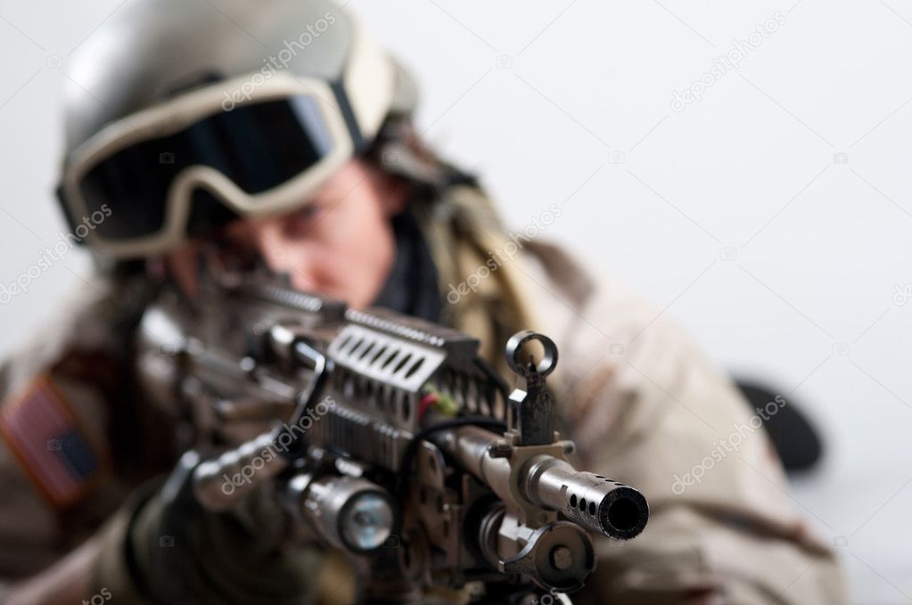 Soldier with rifle against white background. Shallow depth of field