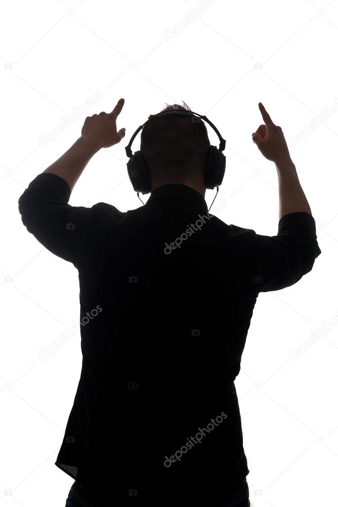 Man silouette with ear-phones listening to music against white background
