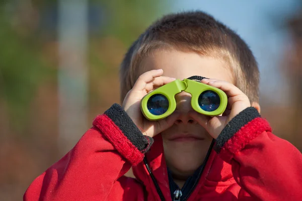 Portrét mladého chlapce s dalekohledem. boční pohled — Stock fotografie