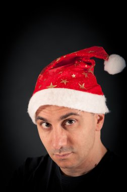 adam siyah arka plan üzerinde çapraşık ifade ve Noel şapka ile