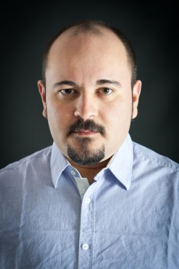 koyu arka plan üzerinde ciddi bir ifade ile adam portresi