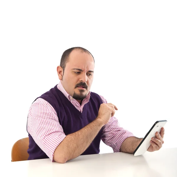 Молодий чоловік дивиться на планшет із заплутаним виразом — стокове фото
