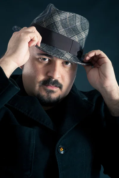 Confident man portrait with hat on dark background — Stock Photo, Image