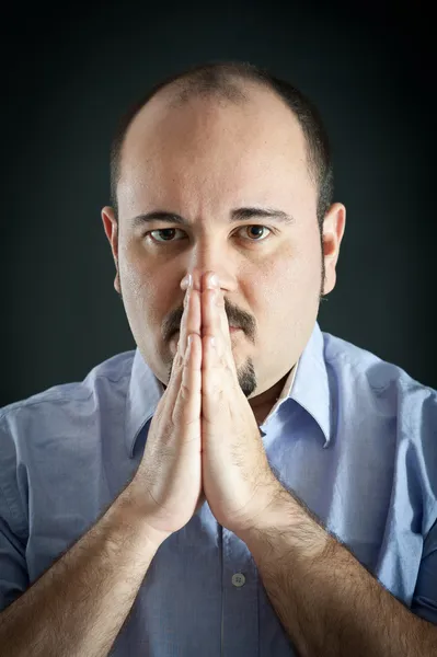 Retrato de hombre con las manos en oración sobre fondo oscuro —  Fotos de Stock