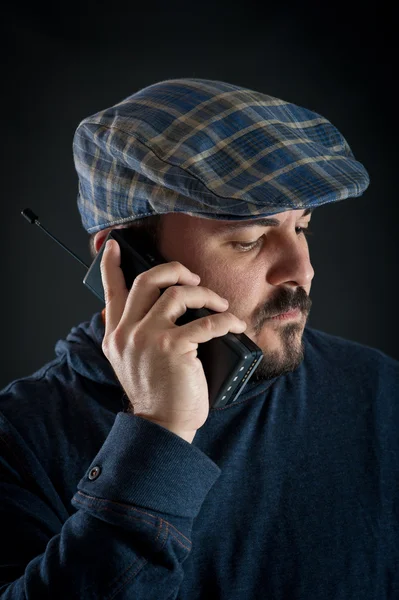 Homem falando ao telefone contra fundo preto — Fotografia de Stock