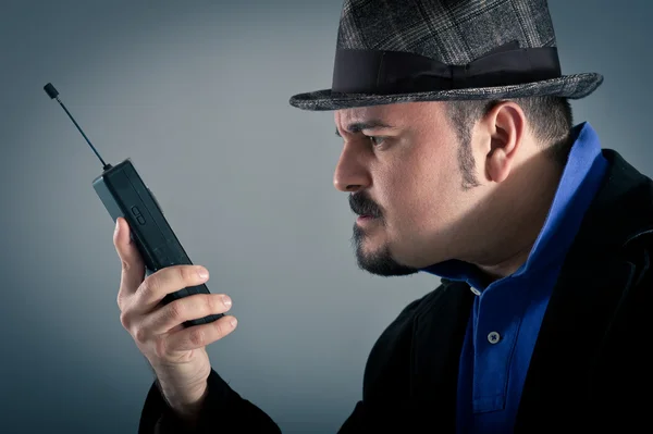 Homem irritado falando ao telefone contra fundo cinza — Fotografia de Stock