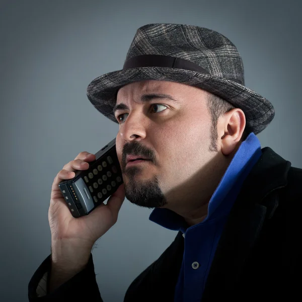 Hombre hablando por teléfono contra fondo gris — Foto de Stock