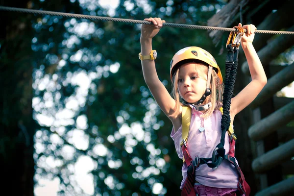 Ung flicka klättra i träd i Dolomiterna, Italien — Stockfoto