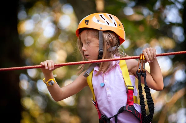 Ung flicka klättra i träd i Dolomiterna, Italien — Stockfoto