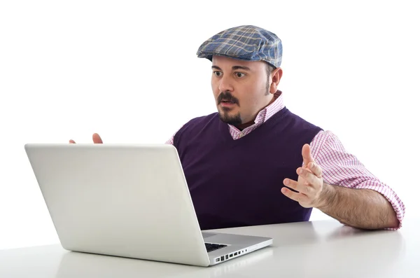 Portrait of a surprised young man looking at laptop against white background — Stock Photo, Image