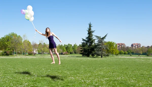 Levitatie van mooi meisje met ballonnen — Stockfoto
