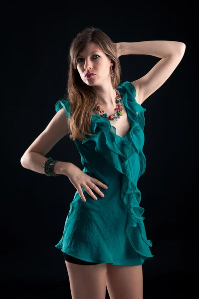 Koyu arka planı yeşil elbise ile güzel kız portresi — Stok fotoğraf