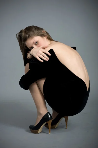 Retrato de bela loira caucasiano menina sentado e mostrando ela de volta — Fotografia de Stock
